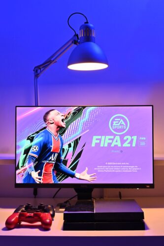 black flat screen tv turned on displaying man in blue and red jersey shirt