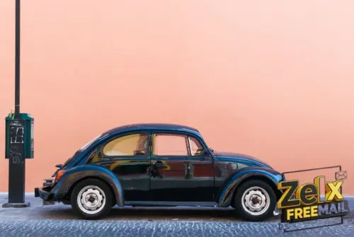 black Volkswagen Beetle beside beige wall