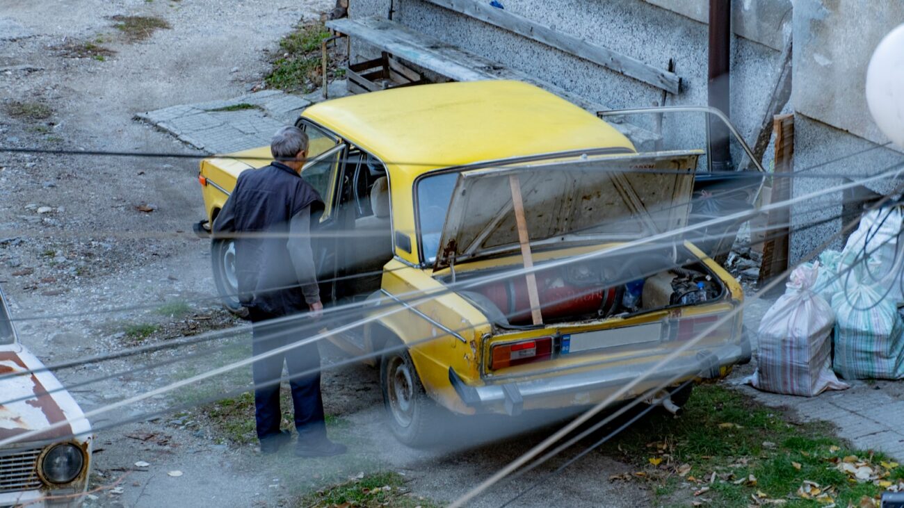 a man standing next to a yellow car