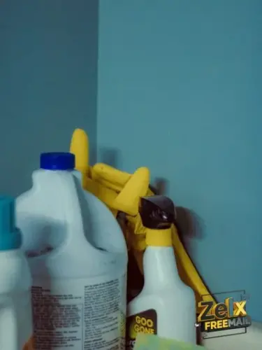 A close up of a bottle of cleaner next to a mirror