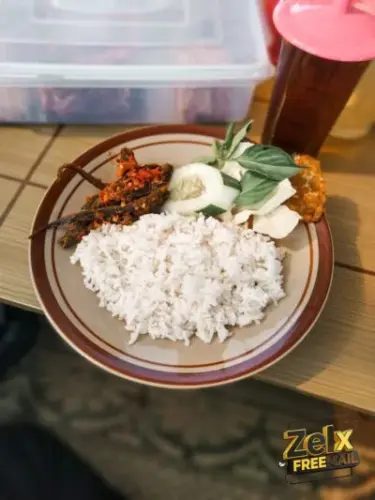 a plate of rice, meat and vegetables on a table