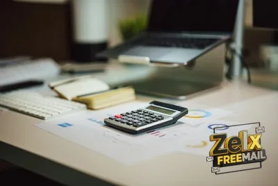 a calculator sitting on top of a table next to a laptop